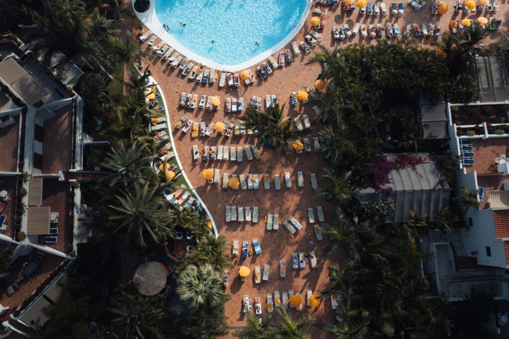 Ariel views of people by large pool in beach chairs