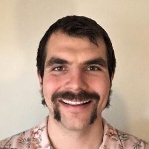 Portrait of man with pink Hawaii shirt on white background.